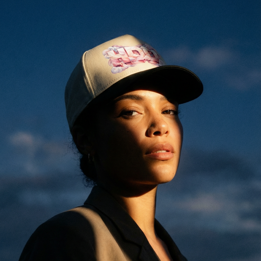 Person wearing a cap with a floral design against a blue sky
